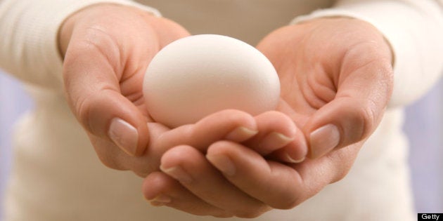 Woman holding egg, close-up