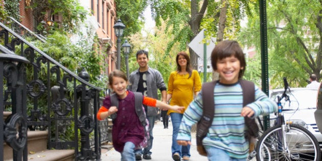 Children running ahead of parents on sidewalk, Manhattan, New York City