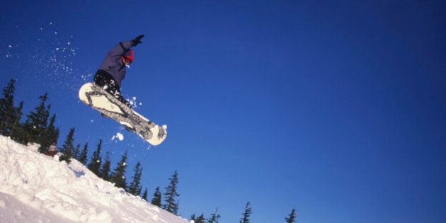 Mt Washington ski resort - boy jumping on snowbord, Vancouver Island, British Columbia, Canada.