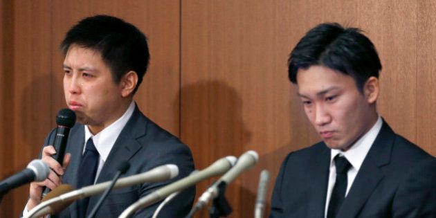 Japanese badminton player Kenichi Tago, left, speaks with his teammate Kento Momota as they apologize for gambling at an illegal casino during a press conference in Tokyo, Friday, April 8, 2016. The two were admitted to gambling at an illegal casino, damaging their chances of competing at the Olympics in Rio de Janeiro. (AP Photo/Shizuo Kambayashi)