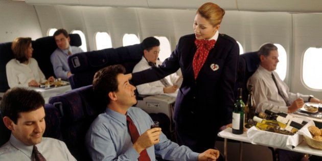 Executive enjoying in-flight meal with wine
