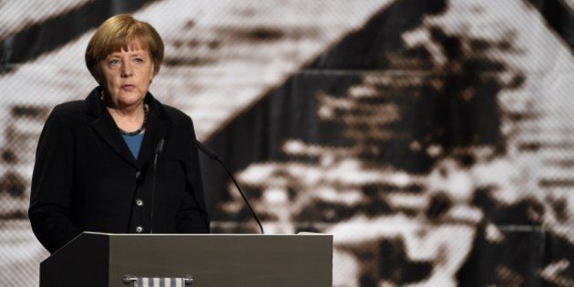 German Chancellor Angela Merkel stands in front of an historic picture of the Auschwitz concentration camp as she gives a speech during the International Auschwitz Committees remembrance ceremony to mark the 70th anniversary of the liberation of the Nazi death camp on January 26, 2015 in Berlin. The International Auschwitz Committee (IAC) was founded by survivors of the Auschwitz concentration camp aiming to let the world know what happened in the concentration and extermination camp Auschwitz-Birkenau and to look after the interests of the survivors. AFP PHOTO / TOBIAS SCHWARZ (Photo credit should read TOBIAS SCHWARZ/AFP/Getty Images)