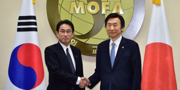 South Korean Foreign Minister Yun Byung-Se, right, and his Japanese counterpart Fumio Kishida pose for a photo at the start of their meeting at Foreign Ministry in Seoul Monday, Dec. 28, 2015. The foreign ministers met Monday to try to resolve a decades-long impasse over Korean women forced into Japanese military-run brothels during World War II. (Jung Yeon-je/Pool Photo via AP)