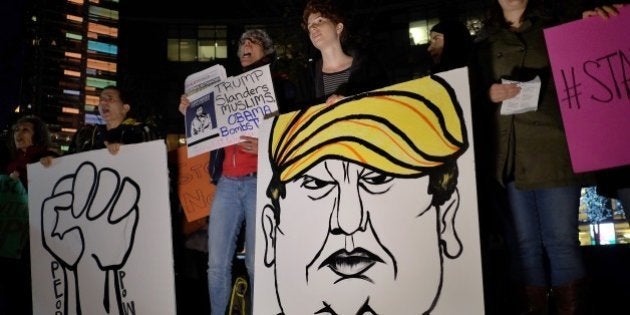 Human rights activists and people from Muslim community display a placard depicting US presidential hopeful Donald Trump during a demonstration in New York on December 10, 2015 in solidarity for Syrian and Iraqi refugees. AFP PHOTO/JEWEL SAMAD / AFP / JEWEL SAMAD (Photo credit should read JEWEL SAMAD/AFP/Getty Images)