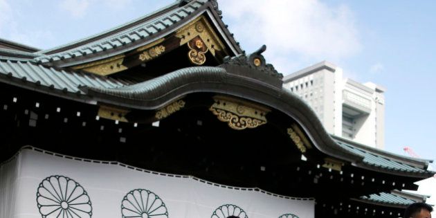 Visitors wipe their faces after offering prayers to the war dead at the Yasukuni Shrine in Tokyo, Saturday, Aug. 15, 2015. Japan marked Saturday the 70th anniversary of the end of World War II. (AP Photo/Shuji Kajiyama)