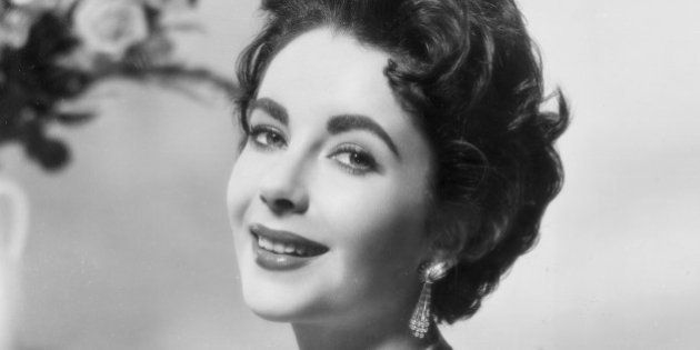 circa 1952: Promotional portrait of British-born actor Elizabeth Taylor smiling, wearing a sleeveless sequined gown. (Photo by Hulton Archive/Getty Images)