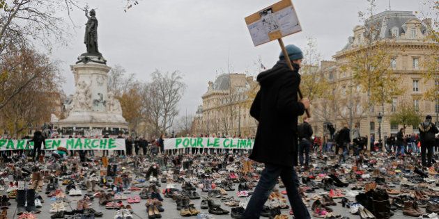 A man walks between shoes as hundreds of pairs of shoes are displayed at the place de la Republique, in Paris, as part of a symbolic and peaceful rally called by the NGO Avaaz