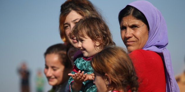 DEREK, SYRIA - NOVEMBER 13: Yazidi refugees watch as othes celebrate news of the liberation of their homeland of Sinjar from ISIL extremists, while at a refugee camp on November 13, 2015 in Derek, Rojava, Syria. Kurdish Peshmerga forces in Iraq say they have retaken Sinjar, with the help of airstrikes from U.S. led coalition warplanes. The Islamic State captured Sinjar in August 2014, killing many and sexually enslaving thousands of Yazidi women. (Photo by John Moore/Getty Images)