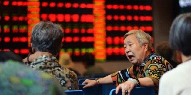 A stock investor reacts in front of a screen showing stock market movements in a brokerage house in Shanghai on July 6, 2015. Shanghai stocks were up 2.15 percent at midday on July 6 after the government unveiled its biggest package of measures so far to shore up the slumping market, but an initial surge was pared as analysts questioned their effect. AFP PHOTO / JOHANNES EISELE (Photo credit should read JOHANNES EISELE/AFP/Getty Images)