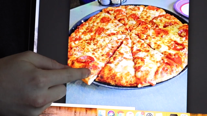 Shane Dawson points out the uneven pizza slices on his computer.