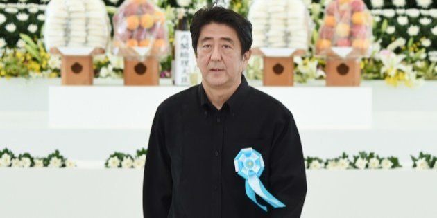 Japanese Prime Minister Shinzo Abe returns his seat after offering a flower at an altar during a memorial service for those who died in the battle of Okinawa during World War II at the Peace Memorial Park in Itoman, Japan's southern islands prefecture of Okinawa, on June 23, 2015. Japan on June 23 marked the 70th anniversary of the end of the Battle of Okinawa, the bloodiest episode in the Pacific War, which killed 200,000 people. AFP PHOTO / Toru YAMANAKA (Photo credit should read TORU YAMANAKA/AFP/Getty Images)