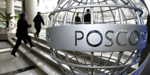 Visitors walk past a sculpture displaying the Posco logo at the company's headquarters in Seoul, South Korea, Thursday, Jan. 11, 2007. Posco, the world's third largest steel maker, said Thursday its fourth-quarter profit soared, helped mainly by higher steel prices and lower raw material costs. (AP Photo/ Lee Jin-man)