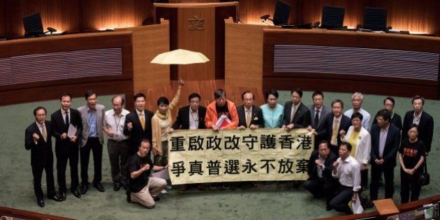 Hong Kong pro-democracy lawmakers display a banner after a vote at the city's legislature in Hong Kong on June 18, 2015. Hong Kong lawmakers rejected a Beijing-backed political reform package on June 18 as pro-democracy legislators united to vote down the divisive electoral roadmap that has sparked mass protests. AFP PHOTO / Philippe Lopez (Photo credit should read PHILIPPE LOPEZ/AFP/Getty Images)