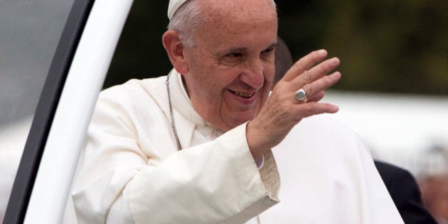 Pope Francis parades in the popemobile along the Benjamin Franklin Parkway in Philadelphia, Sunday, Sept. 27, 2015, on his way to celebrate Mass. (AP Photo/Carolyn Kaster)