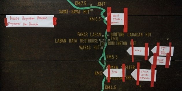 Pieces of paper showing various Malaysian rescue teams mark their current positions on a summit trail information board, heading towards Mount Kinabalu, at the Timpohon gate checkpoint a day after an earthquake in Kundasang, a town in the district of Ranau on June 6, 2015. Malaysian rescuers brought 137 hikers down to safety on June 6 after an earthquake had stranded them atop Mount Kinabalu, but reports said at least two people were killed and 16 remained missing. AFP PHOTO / MOHD RASFAN (Photo credit should read MOHD RASFAN/AFP/Getty Images)