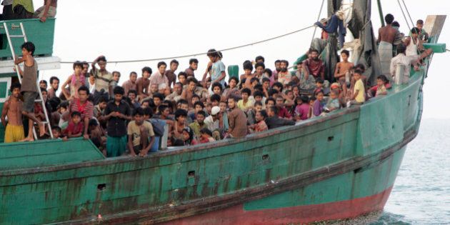 FILE - In this Wednesday, May 20, 2015 file photo, migrants sit on their boat as they wait to be rescued by Acehnese fishermen on the sea off East Aceh, Indonesia. Many of the thousands of migrants abandoned at sea in Southeast Asia this month are Rohingya Muslims who fled their home country of Myanmar. The Rohingya are a Muslim minority in predominantly Buddhist Myanmar, also known as Burma. Numbering around 1.3 million, they are concentrated in western Rakhine state, which neighbors Bangladesh. (AP Photo/S. Yulinnas, File)