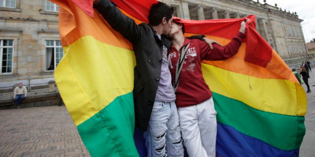 LGBT activists kiss in front of Colombia's Congress building to show support for a proposed bill to legalize same sex marriage, being debating on by legislators, in Bogota, Tuesday, Nov. 27, 2012. (AP Photo/Fernando Vergara)
