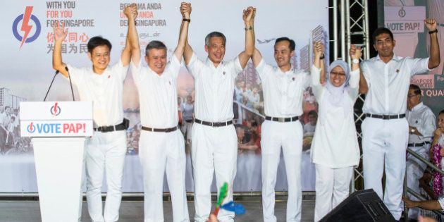 Lee Hsien Loong, Singapore's prime minister and leader of the People's Action Party (PAP), center, gestures with his team at an election results rally in Singapore on Saturday, Sept. 12, 2015. Singapore Prime Minister Lee Hsien Loong's People's Action Party won a majority of parliament seats, returning the party to power to continue more than five decades of rule. Photographer: Nicky Loh/Bloomberg via Getty Images