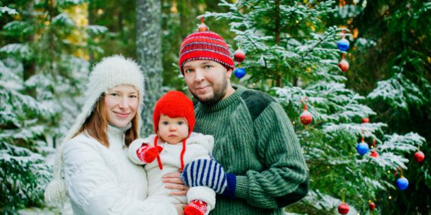 Finland, Heinola, Family with baby girl (12-17 months) near pine tree in forest