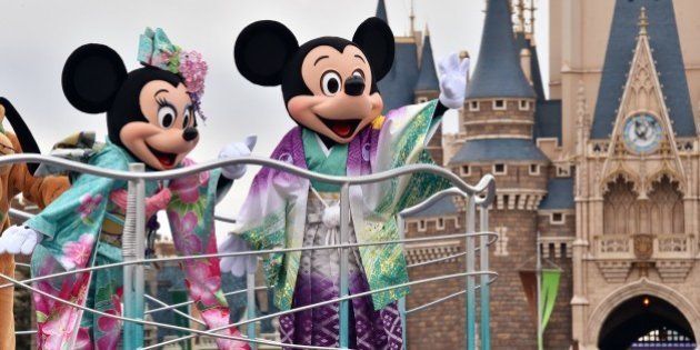 Disney characters Mickey (R) and Minnie Mouse (L), dressed in traditional Japanese kimonos, wave to greet guests from a float during the theme park's annual New Year's Day parade at Tokyo Disneyland in Urayasu, suburban Tokyo on January 1, 2015. The time around New Year's Day is one of the biggest holiday periods every year in Japan. AFP PHOTO / Yoshikazu TSUNO (Photo credit should read YOSHIKAZU TSUNO/AFP/Getty Images)