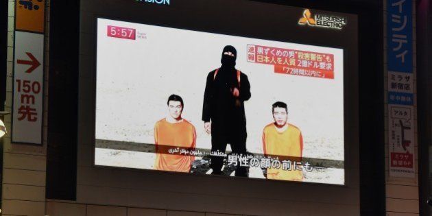 People watch a large TV screen in Tokyo on January 20, 2015 showing news reports about two Japanese men (in orange) who have been kidnapped by the Islamic State group. Japanese Prime Minister Shinzo Abe, speaking at a press conference during a visit to Jerusalem on January 20, demanded that the Islamic State group immediately free two Japanese hostages unharmed after the jihadists posted a video threat to kill them. AFP PHOTO / Yoshikazu TSUNO (Photo credit should read YOSHIKAZU TSUNO/AFP/Getty Images)