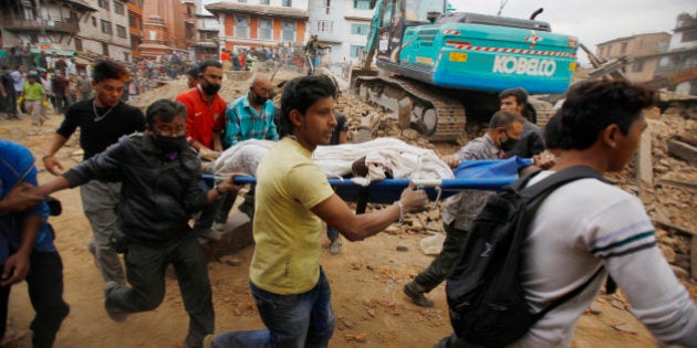 Volunteers carry the body of a victim on a stretcher, recovered from the debris of a building that collapsed after an earthquake in Kathmandu, Nepal, Saturday, April 25, 2015. A strong magnitude-7.9 earthquake shook Nepal's capital and the densely populated Kathmandu Valley before noon Saturday, causing extensive damage with toppled walls and collapsed buildings, officials said. (AP Photo/ Niranjan Shrestha)