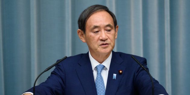 Yoshihide Suga, chief cabinet secretary of Japan, listens during a press conference at the official residence of Japan's Prime Minister Shinzo Abe, not pictured, in Tokyo, Japan, on Wednesday, Aug. 3, 2016. In a cabinet reshuffle that leaves most key personnel in place, Abe appointed a hawkish ally he once dubbed 'Joan of Arc' as defense minister amid tensions with his country's neighbors. Photographer: Akio Kon/Bloomberg via Getty Images