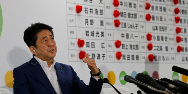 Japan's Prime Minister Shinzo Abe, leader of the Liberal Democratic Party, answers a question from reporter during a TV interview on the ballot counting of the parliamentary upper house election at their party headquarters in Tokyo, Sunday, July 10, 2016. (AP Photo/Shizuo Kambayashi)