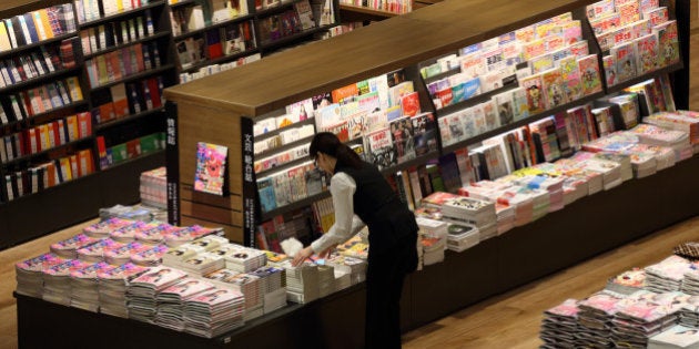 A worker arranges books at a book store in the Aeon Mall Makuhari Shintoshin shopping mall, operated by Aeon Mall Co., during a media preview ahead of the mall's opening in Chiba, Japan, on Monday, Dec. 16, 2013. Large Japanese businesses pared their projections for capital spending this fiscal year, signaling challenges for Abenomics as a sales-tax increase looms in April. Photographer: Tomohiro Ohsumi/Bloomberg via Getty Images