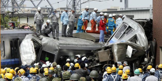 AMAGASAKI, JAPAN: Rescue workers and self defence force soldiers search for injured passengers from a crashed commuter train at Amagasaki city near Osaka, western Japan 25 April 2005. At least 37 people were killed and more than 220 others injured in a train crash 27 April in western Japan, police ad firefighters said. AFP PHOTO/Yoshikazu TSUNO (Photo credit should read YOSHIKAZU TSUNO/AFP/Getty Images)