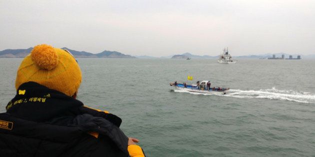 JINDO-GUN, SOUTH KOREA - MARCH 22: In this handout photo released by the Asan City, A relative of victim of the Sewol ferry disaster looking at the Chinese salvaging vessels (C far) as it prepare to lift the wreck of the Sewol ferry in the sea on March 22, 2017 in Jindo-gun, South Korea. The South Korean government attempted to raise the Sewol ferry on March 22, 2017. The Sewol sank off the Jindo Island in April 2014 leaving more than 300 people dead and nine of them still remain missing. (Photo by Asan City via Getty Images)