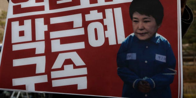 A protester demanding arrest warrant of ousted South Korean President Park Geun-hye holds a photograph of Park during a protest outside the prosecutor? office in Seoul, South Korea, on Tuesday, March 20, 2017. (Photo by STR/NurPhoto via Getty Images)