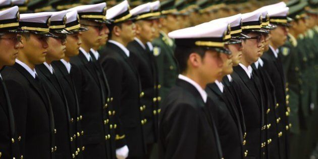 Graduates of the National Defense Academy wearing uniforms of the Self-Defense Forces attend their cadet appointment ceremony in Yokosuka, Kanagawa Prefecture on March 22, 2015. A total of 492 students graduated from the school this year. AFP PHOTO / KAZUHIRO NOGI (Photo credit should read KAZUHIRO NOGI/AFP/Getty Images)