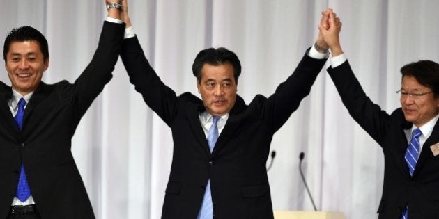 Newly elected opposition Democratic Party of Japan (DPJ) leader Katsuya Okada (C) raises his arms with two other candidates, Goshi Hosono (L) and Akira Nagatsuma (R), during the party's leadership election in Tokyo on January 18, 2015. Okada, a 61-year-old Harvard-trained former deputy prime minister, will have his work cut out rebuilding public trust in the nominally centre-left party, whose three years in power to December 2012 were characterised by power struggles, policy flip-flops and diplomatic mis-steps. AFP PHOTO / TOSHIFUMI KITAMURA (Photo credit should read TOSHIFUMI KITAMURA/AFP/Getty Images)