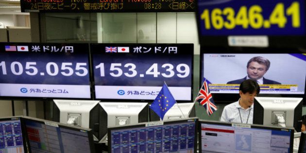 An employees of a foreign exchange trading company works next to monitors displaying television news on Britain's EU referendum, Japan's Nikkei share average (top R), the Japanese yen's exchange rate against British pound (C) and the U.S. dollar (L) in Tokyo, Japan, June 24, 2016. REUTERS/Issei Kato