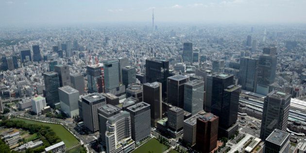 Commercial buildings, bottom, stand in the Marunouchi and Otemachi districts in this aerial photograph taken in Tokyo, Japan, on Wednesday, June 24, 2015. The Abe administration aims to cap increases in spending as it tries to rein in the world's heaviest debt load while sustaining a recovery from two decades of stagnation. Photographer: Kiyoshi Ota/Bloomberg via Getty Images