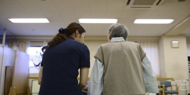 A physical therapist, left, sits talking to a patient at Jukoukai Hospital in Tokyo, Japan, on Thursday, Sept. 11, 2014. Japan spent more than any other country in the world keeping people 65 years or older in hospital in 2011, according to Organization for Economic Cooperation and Development data, while medical expenses are forecast to rise 54 percent to 54 trillion yen ($506 billion) in fiscal 2025 compared with 2012, according to the Ministry of Health, Labor and Welfare. Photographer: Akio Kon/Bloomberg via Getty Images
