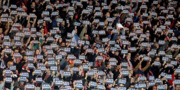 Guingamp's supporter hold signs reading 'Je suis Charlie' (I am Charlie) to pay tribute to the victims of the Charlie Hebdo attack during the French L1 football match between Guingamp and Lens at the Roudourou stadium in Guingamp, western France, on January 10, 2015. AFP PHOTO / FRED TANNEAU (Photo credit should read FRED TANNEAU/AFP/Getty Images)