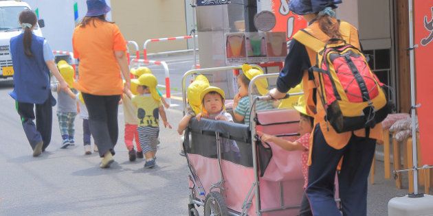 Tokyo Japan - May 22, 2015: Japanese kindergarden kids and teachers walk on street in Asakusa Tokyo Japan.