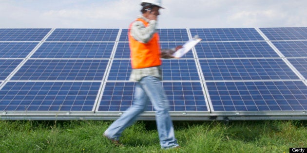 Mixed race man walking past solar panels