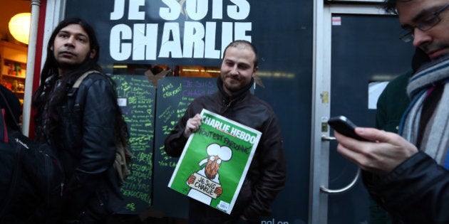 LONDON, ENGLAND - JANUARY 16: A man holds a copy of Charlie Hebdo magazine as he leaves a French bookstore on January 16, 2015 in London, England. People queued since the early hours outside London bookshops selling the latest edition of French satirical magazine Charlie Hebdo. (Photo by Carl Court/Getty Images)