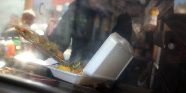 NEW YORK, NY - DECEMBER 19: A food cart worker fills a styrofoam take-out container with food for a customer on December 19, 2013 in New York City. New York's City Council will vote Thursday on a bill that would see expanded polystyrene (EPS), or styrofoam, either banned or added to the city's curbside recycling program. The current version of the bill would give the city's sanitation commissioner until Jan. 1, 2015 to decide whether plastic foam is recyclable. The proposed ban has been met with resistance from the American Chemistry Council and Dart Container among other groups. (Photo by Spencer Platt/Getty Images)