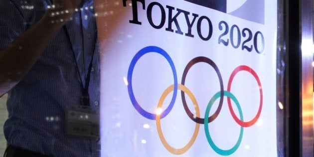 Tokyo metropolitan government officer removes a poster of the logo of the Tokyo 2020 Olympic Games at the Tokyo city hall in Tokyo on September 1, 2015. Tokyo's 2020 Olympics organisers scrapped the event's scandal-hit logo in the latest mishap for the Games after a costs furor forced plans for a 2 billion USD new national stadium to be torn up. AFP PHOTO / JIJI PRESS JAPAN OUT (Photo credit should read JIJI PRESS/AFP/Getty Images)