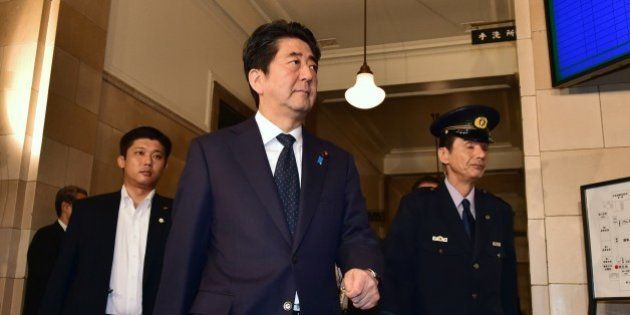 Japanese Prime Minister Shinzo Abe arrives at the Upper House's ad hoc committee session for the controversial security bills at the National Diet in Tokyo on September 14, 2015. Hundreds of people held a rally against the security bills aimed at expanding the remit of the country's armed forces outside the Diet building. AFP PHOTO / Yoshikazu TSUNO (Photo credit should read YOSHIKAZU TSUNO/AFP/Getty Images)