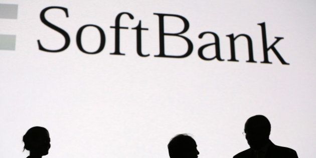 Billionaire Masayoshi Son, chairman and chief executive officer of SoftBank Corp., center, and Colin Powell, former U.S. secretary of state and a board member of Bloom Energy Corp., right, stand silhouetted against a screen after speaking at an event at SoftBank Academia in Tokyo, Japan, on Wednesday, June 18, 2014. SoftBank, the wireless carrier led by Son, wants more discussion on competition in the U.S. as it weighs a bid for T-Mobile US Inc. to create a larger third-ranked mobile operator. Photographer: Yuriko Nakao/Bloomberg via Getty Images