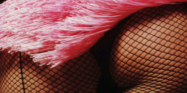 Burlesque performer's buttocks in fishnet stockings, close-up