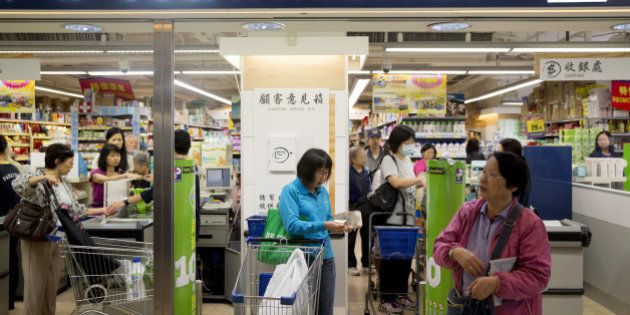 Shoppers exit a ParknShop supermarket, operated by Hutchison Whampoa Ltd., at Lok Fu Plaza, operated by the Link Real Estate Investment Trust (REIT), in Hong Kong, China, on Monday, Nov. 10, 2014. The Link REIT, Asia's largest property trust which owns neighborhood malls, food markets, and car parks, is scheduled to announce interim results on Nov. 13. Photographer: Brent Lewin/Bloomberg via Getty Images