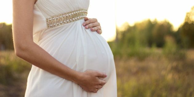 pregnant girl in a white dress at 8 months pregnant