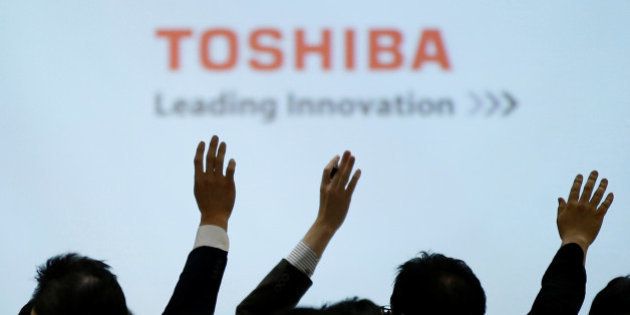 Reporters raise their hands for a question during a news conference by Toshiba Corp CEO Satoshi Tsunakawa and other senior sompany officials at the company's headquarters in Tokyo, Japan February 14, 2017. REUTERS/Toru Hanai