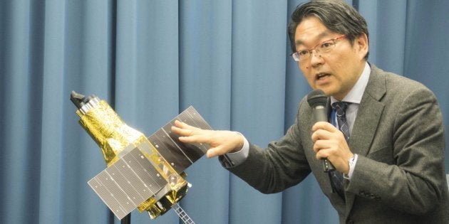 交信不能になったＸ線天文衛星「ひとみ」の模型を使い、説明する宇宙航空研究開発機構（ＪＡＸＡ）の久保田孝教授＝２０１６年４月１日、東京都千代田区のＪＡＸＡ東京事務所